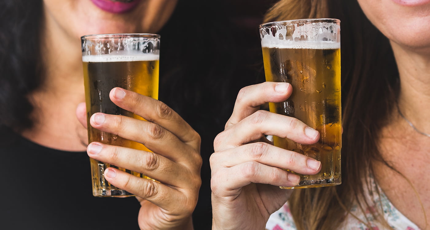 two women holding glasses of beer